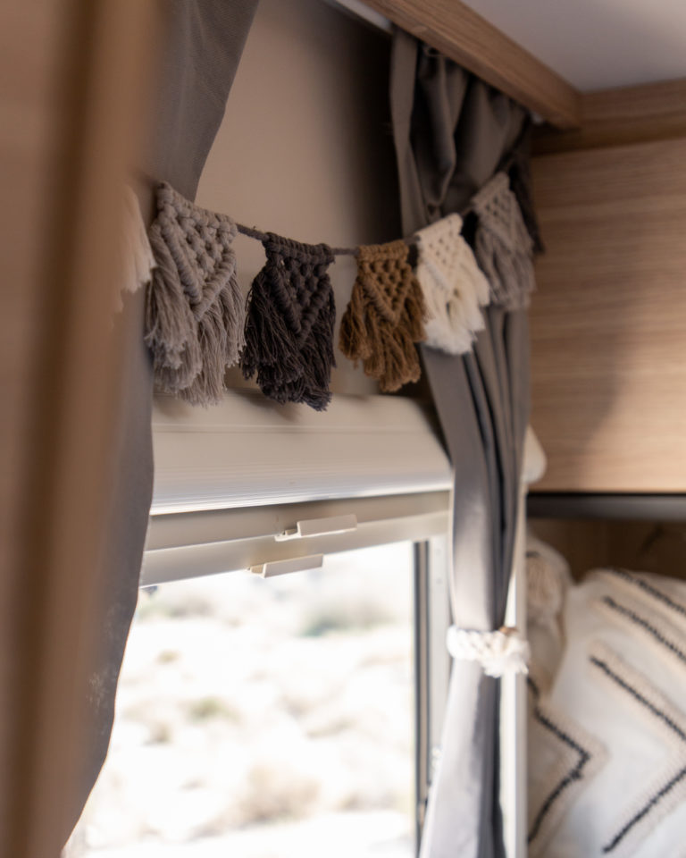 Camping Deko Idee: Makramee Girlande in drei Farben über dem Wohnmobilfenster