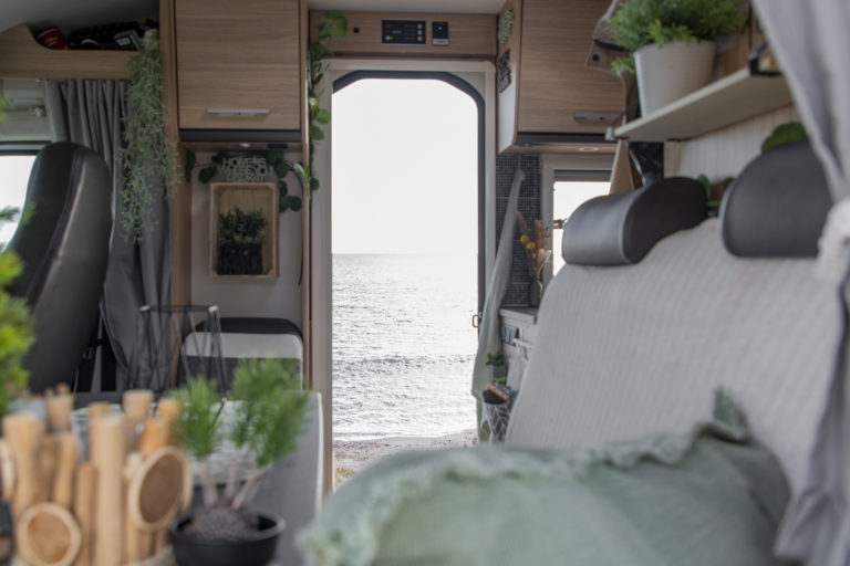 Wohnmobil mit viel Dekoration und Aussicht aufs Meer als Tipp für Camping Deko