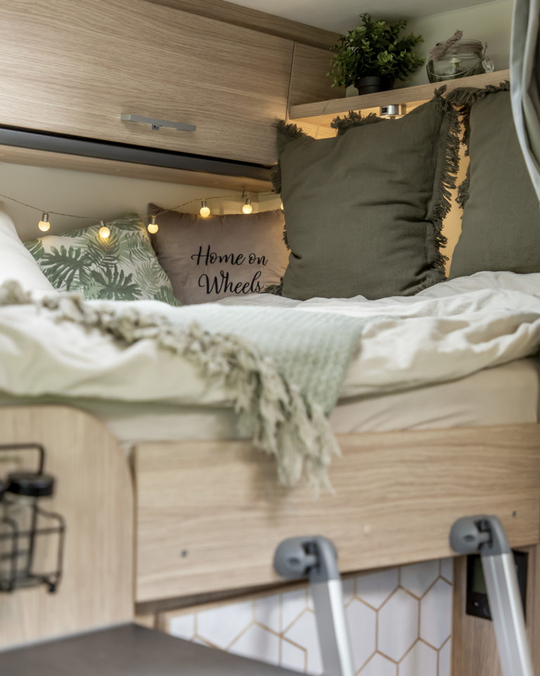 Kissen von H&M auf dem Wohnmobilbett als Tipp für gemütliche Camping Deko