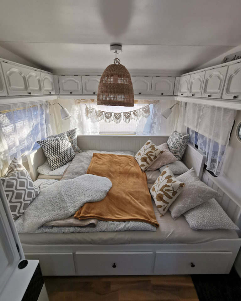 Wohnwagen Deko Inspiration mit ausziehbarem Bett und vielen Kissen