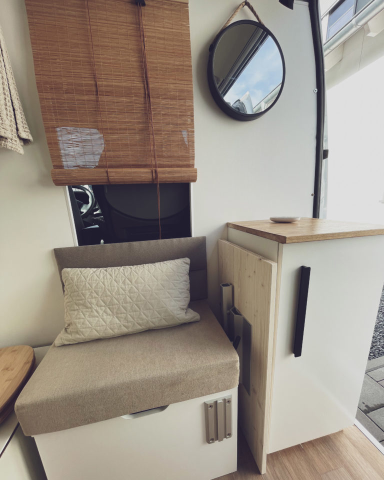 Sitzbereich und Stauhocker im selbstausgebauten Kastenwagen mit Kissen als Deko Inspiration
