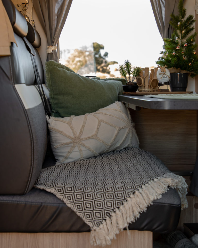Sitzbank im Wohnmobil mit Decke und Kissen als Camping Deko Idee