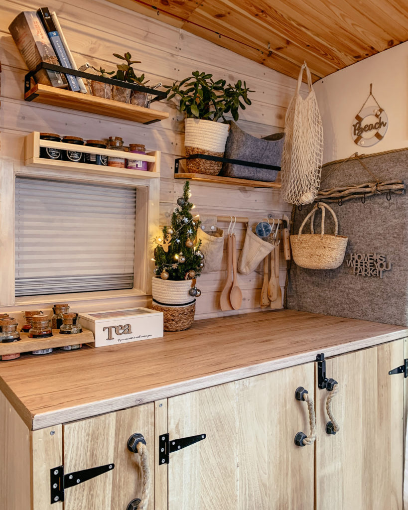 Küche im selbstausgebauten rustikalen Kastenwagen mit Holzschränken und vielen Regalen mit Deko Inspirationen