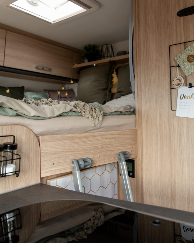 Blick auf das Bett im Wohnmobil mit vielen Kissen als Camping Deko Inspiration