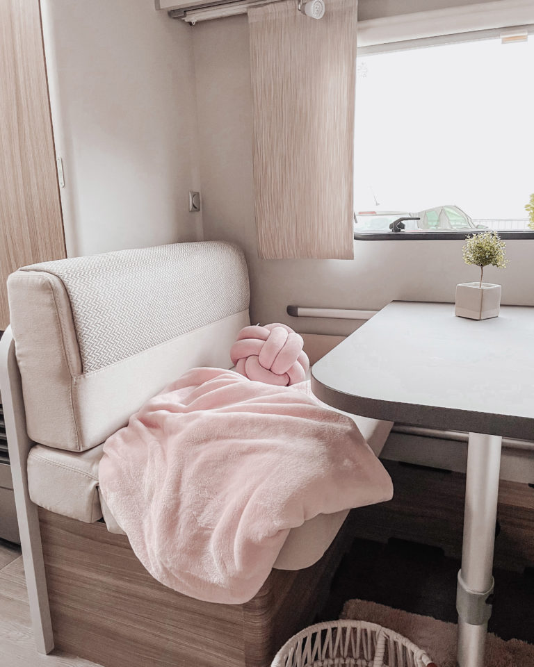 Kindersitzecke im Wohnwagen mit rosa Decke und Kissen als Deko Einrichtung